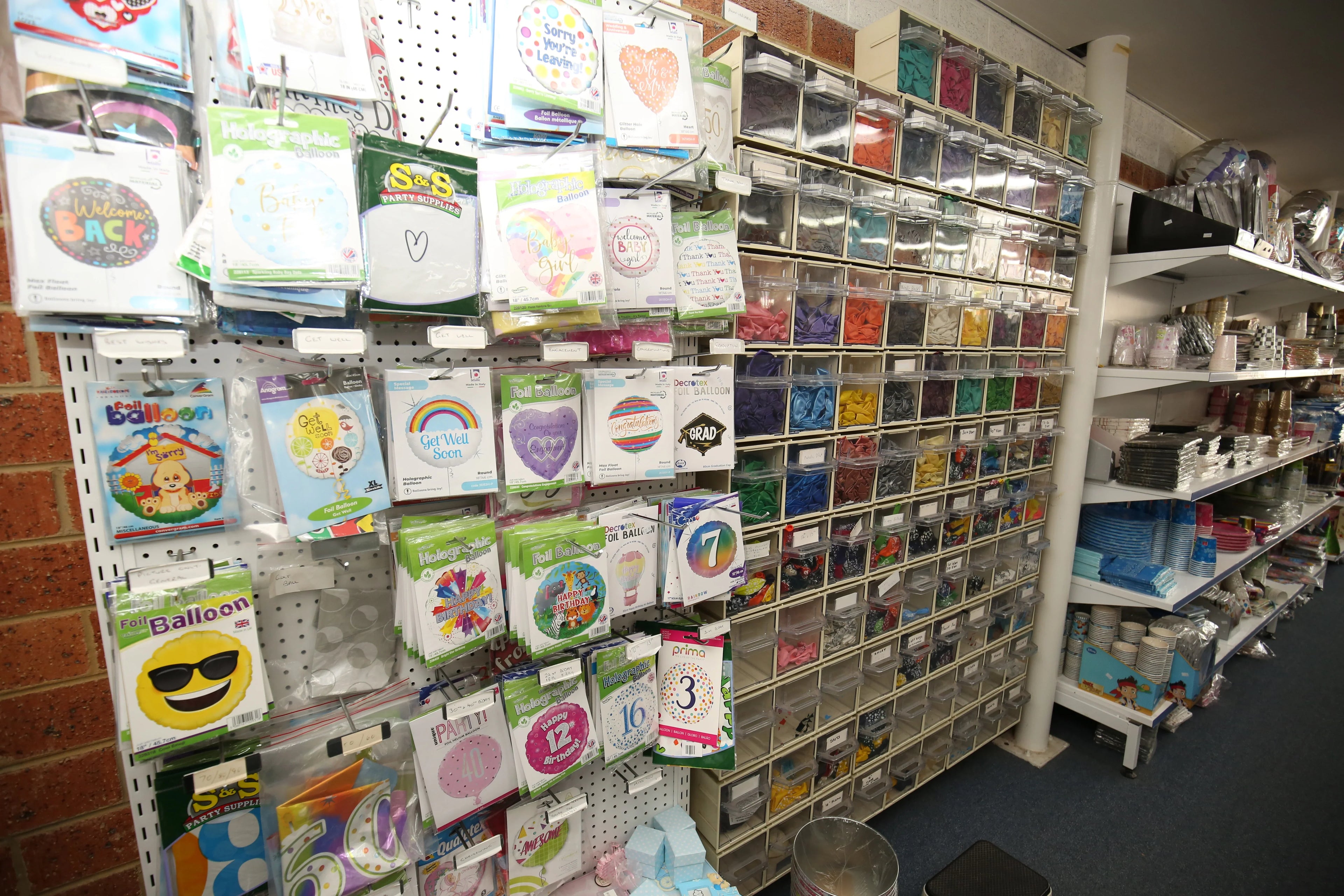 Assorted party balloons and colorful supplies on retail store shelves