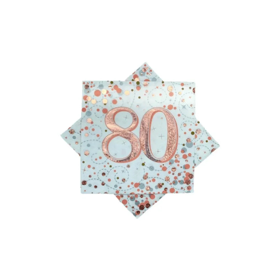 Rose gold 80th birthday napkins with confetti patterns on a light blue background