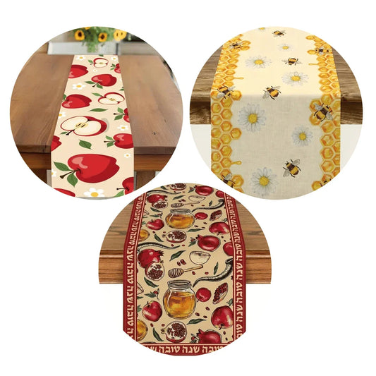 Three decorative table runners featuring apple, bee and honey, and Rosh Hashanah patterns.