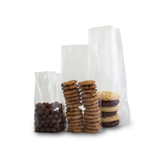 Three clear plastic treat bags filled with chocolate balls, chocolate chip cookies, and sandwich cookies.