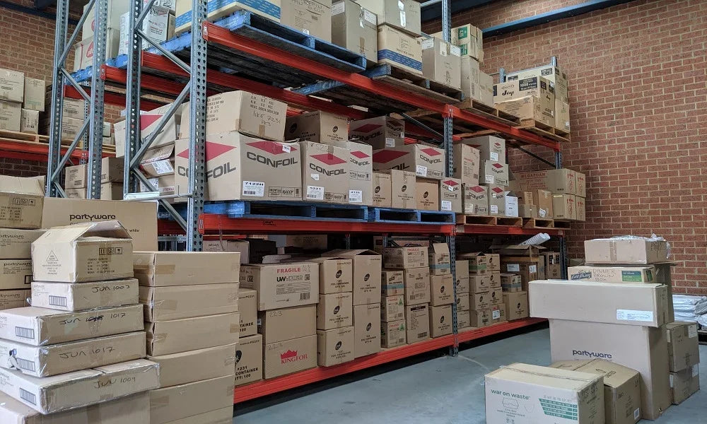 Wholesale catering and packaging supplies stored on industrial warehouse shelving units.