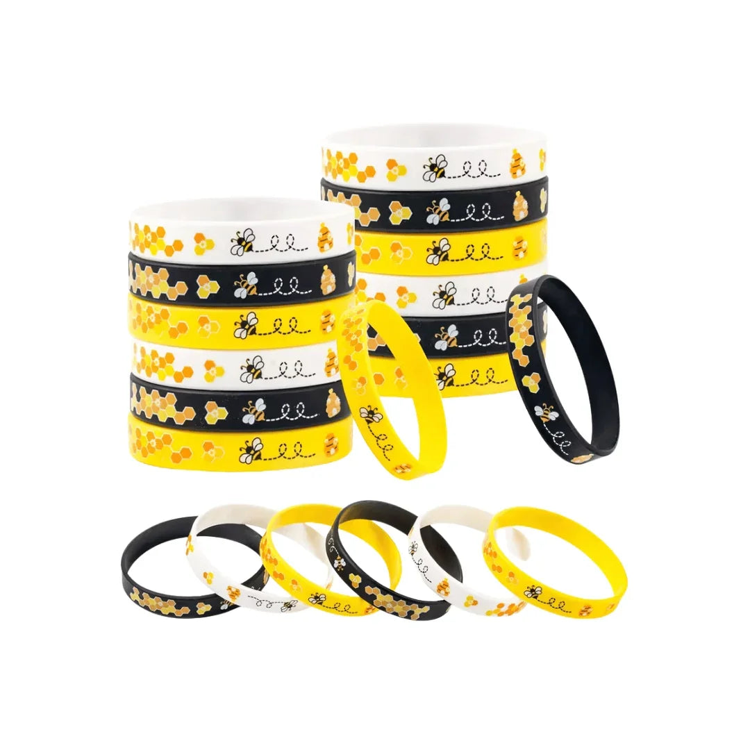 Stacks and rows of yellow, black, and white silicone wristbands with bee and honeycomb patterns