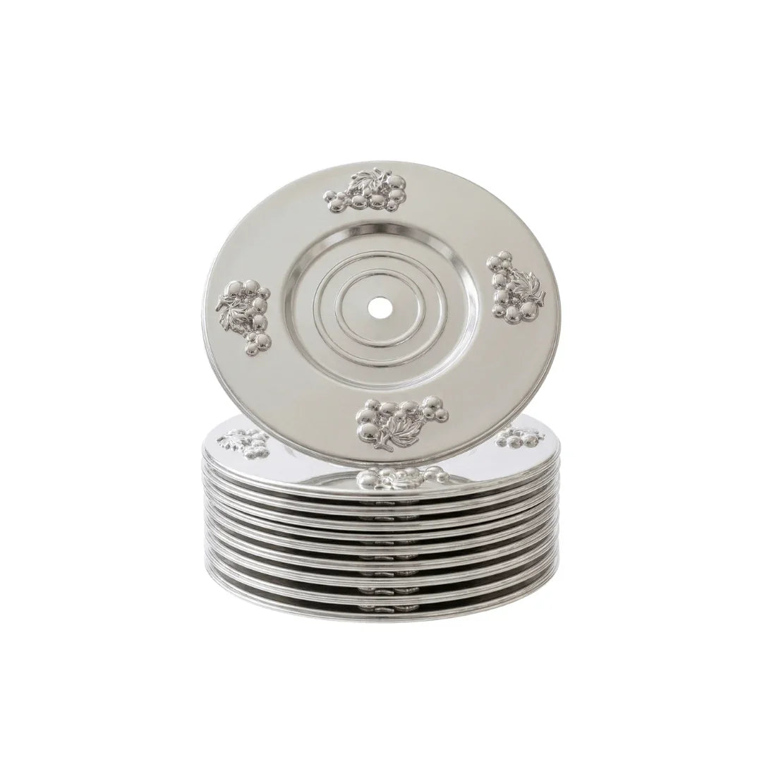 Stack of ornate silver decorative plates with grape motifs