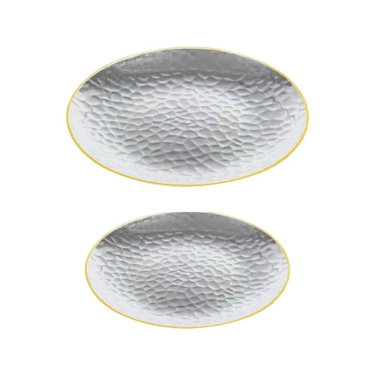 Two oval hammered silver platters with gold rims